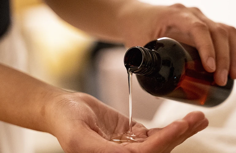 Primer plano de un masaje en Thai Spa Massage con una botella de aceite