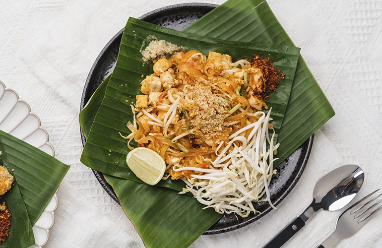 Pad thai servido sobre hojas de plátano