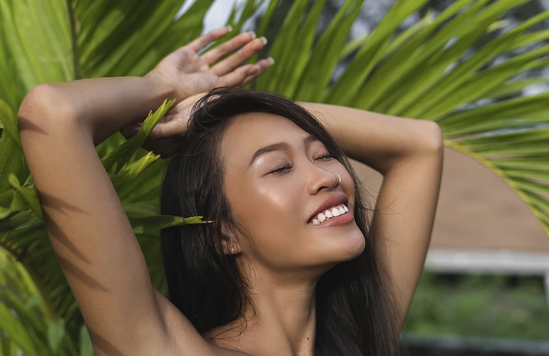 Mujer disfrutando del sol rodeada de vegetación