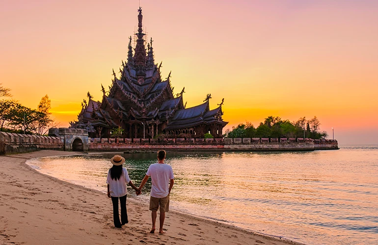 Pareja contemplando el Templo de la Verdad al atardecer en Tailandia
