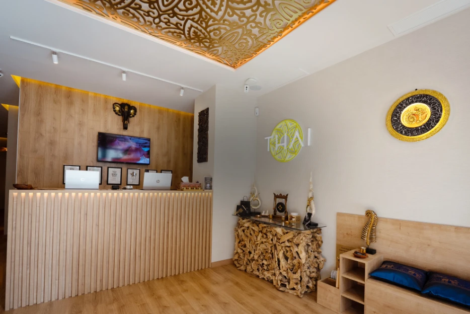 Recepción de spa tailandés en el Eixample de Barcelona con mostrador de madera y decoración tradicional Thai