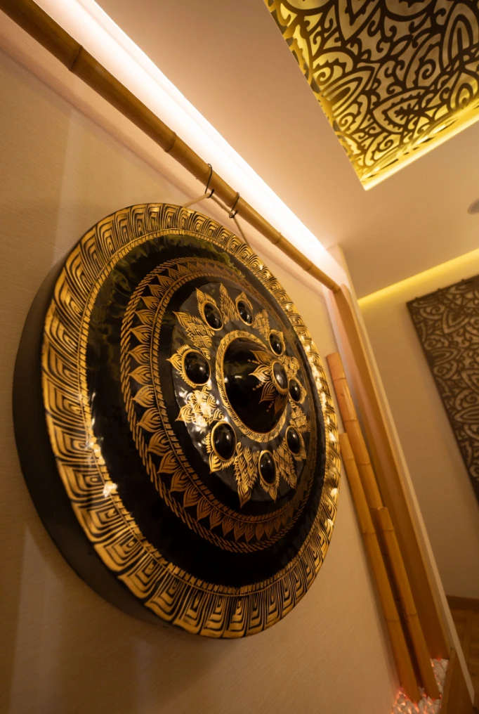 Detalle de decoración tailandesa tradicional con mandala dorado en pared de spa cerca de Verdaguer