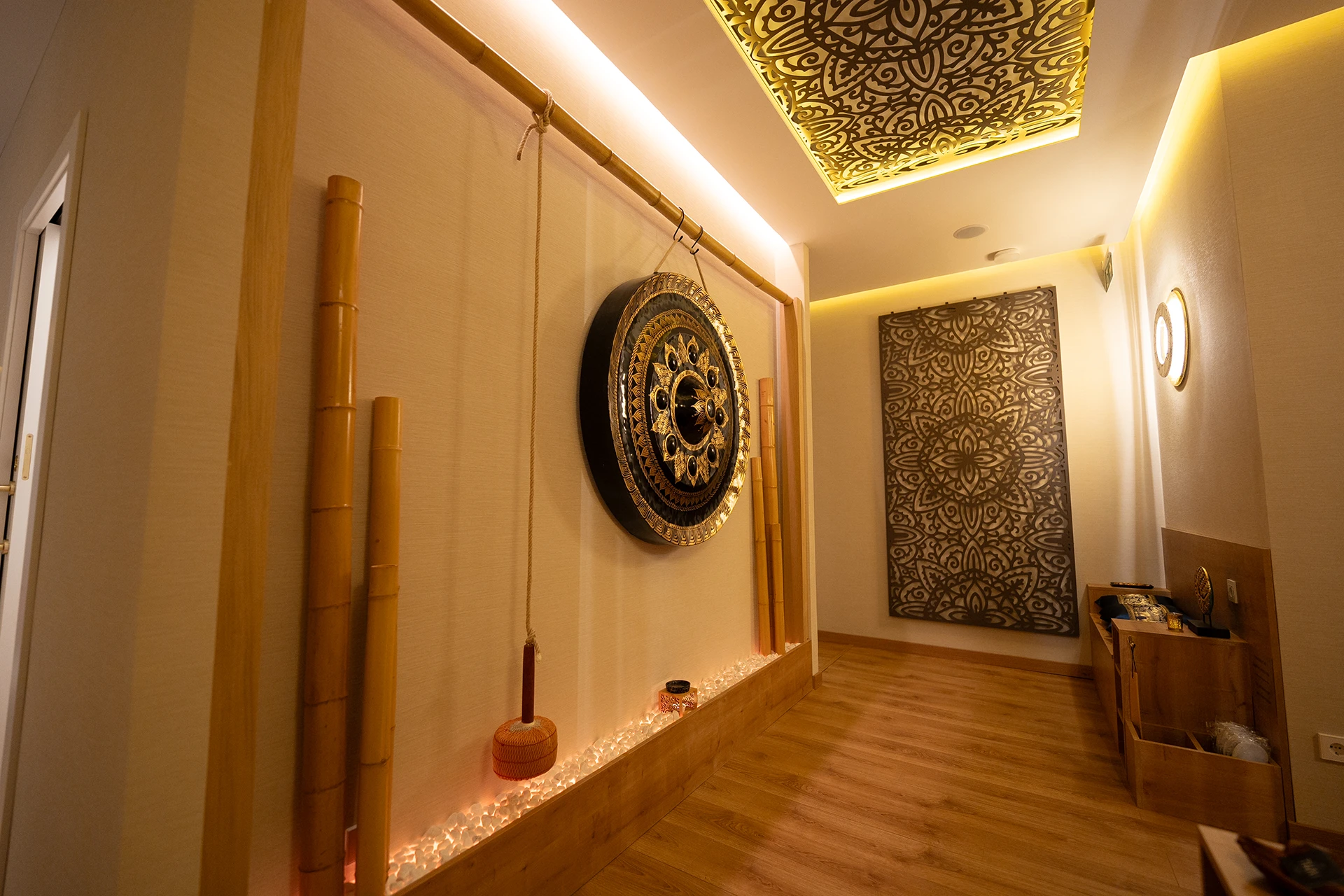 Pasillo interior con gong tailandés y decoración zen en spa de masajes del Eixample Barcelona
