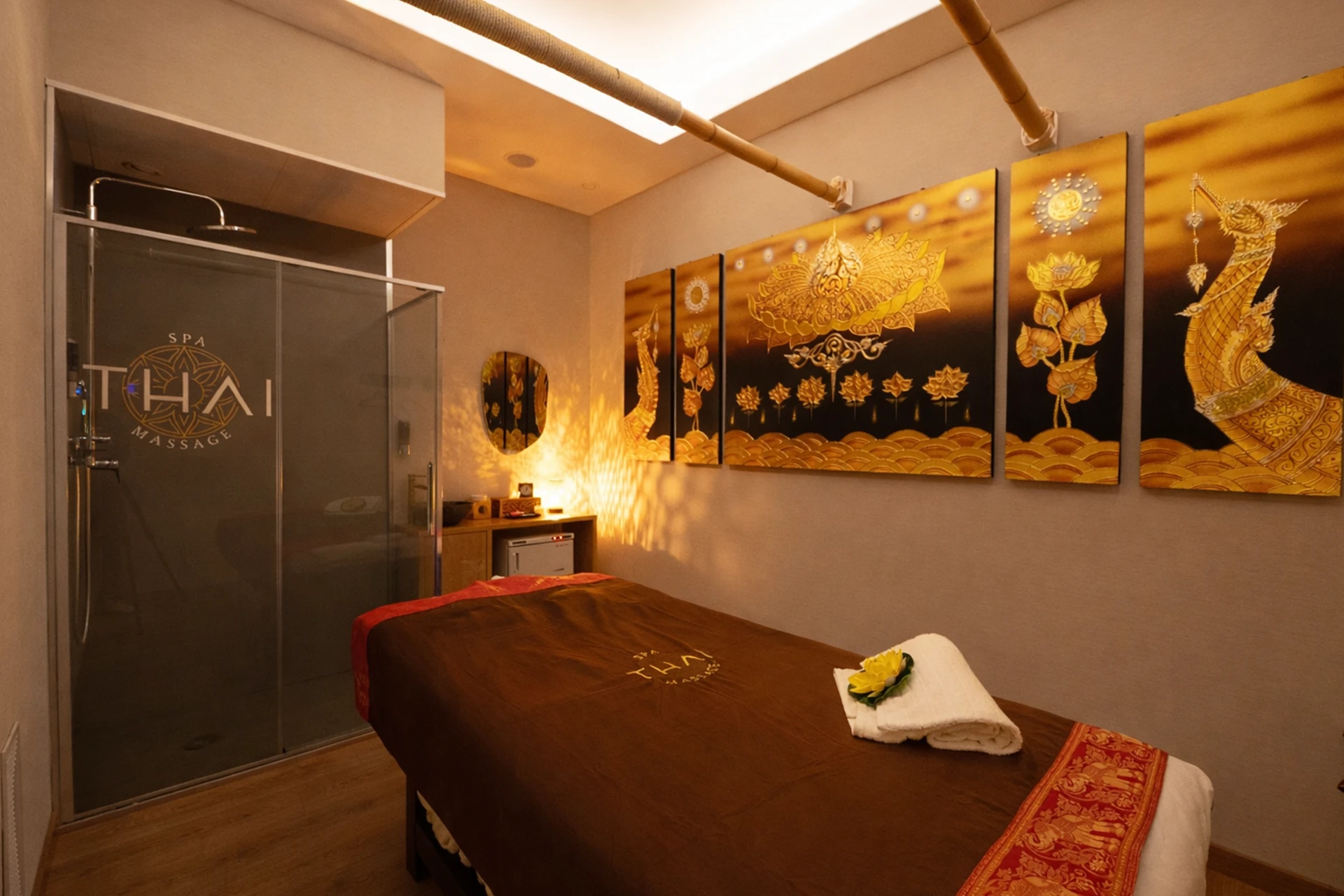 Sala de masaje decorada con cuadros dorados de inspiración tailandesa en spa de Verdaguer