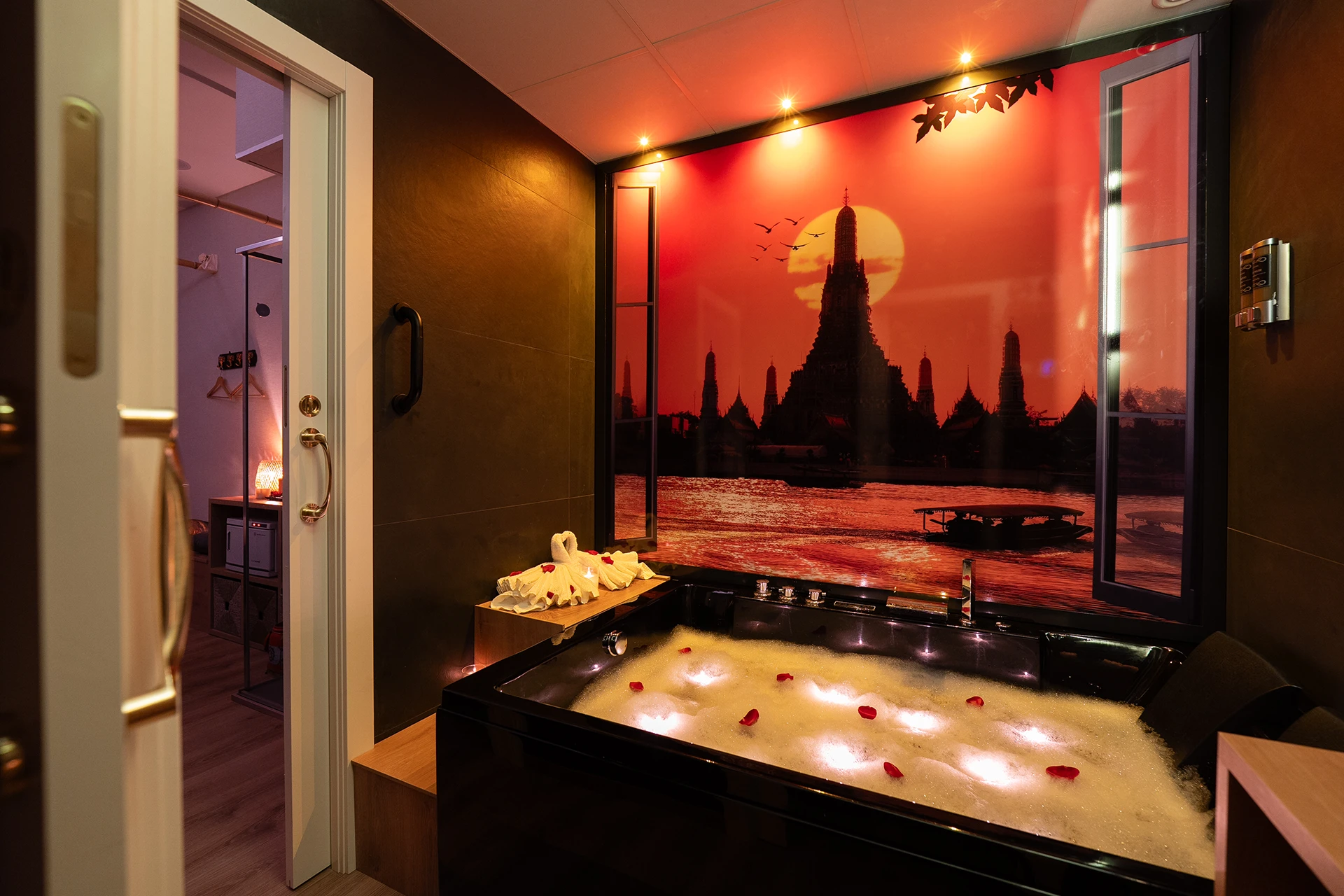 Suite premium con bañera de hidromasaje y mural del Wat Arun en spa de Carrer de Girona
