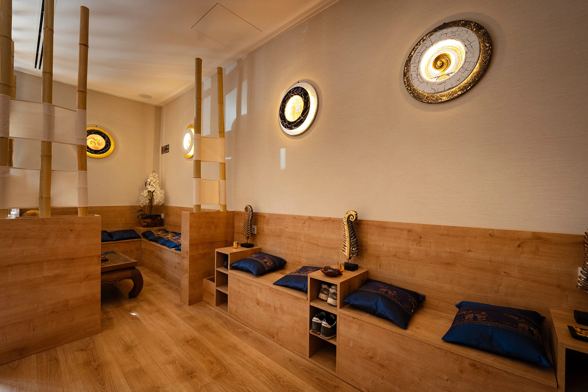 Sala de masaje de pies y reflexología con bancos y cojines tailandeses en spa del Eixample