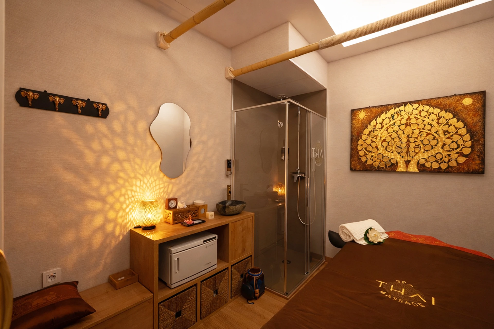 Cabina individual con árbol de la vida dorado y camilla profesional en spa thai Carrer de Girona